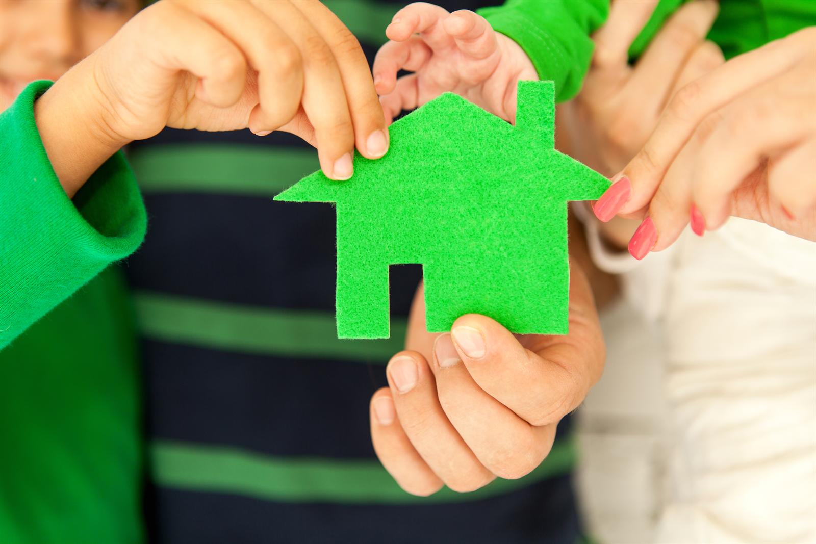 Estate planning in Gauteng — a family holding a green house, representing legacy planning and wealth transfer between generations